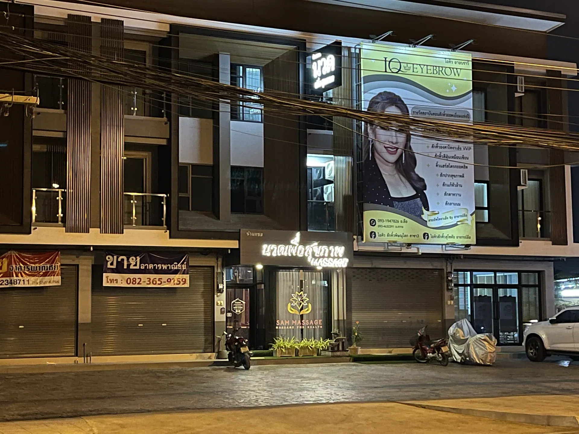 หน้าร้านแซมนวดเพื่อสุขภาพและพื้นที่จอดรถในช่วงกลางคืน